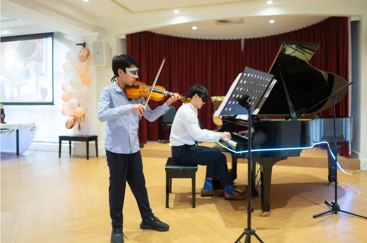 Students and their teacher performing together on stage at a Horizon concert
