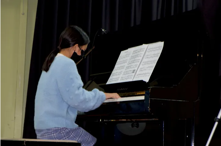 A student learning piano with their teacher at Horizon